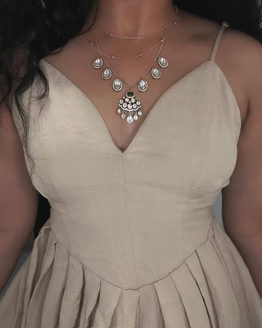 Woman wearing a beige dress with a necklace